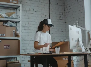 persona en un pequeño almacen donde esta organizando los envios que tiene pendiente