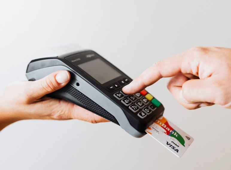 persona pagando mientras otra le pasa la terminal para que pague con su tarjeta