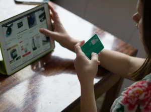 una mujer haciendo compras en linea con su tarjeta de credito