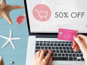 computadora con un descuento y una persona con una tarjeta de credito rosa