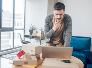 Hombre investigando en su computadora sobre 3 errores que todo emprendedor comete al iniciar un negocio y cómo solucionarlos