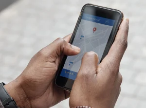 una persona mostrando su telefono con las dos manos mientras revisa maps