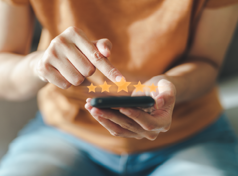 Persona calificando un servicio con cinco estrellas en un teléfono móvil.