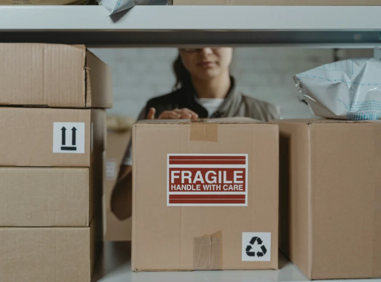 persona cuidando sus paquetes poniendo etiqueta fragil
