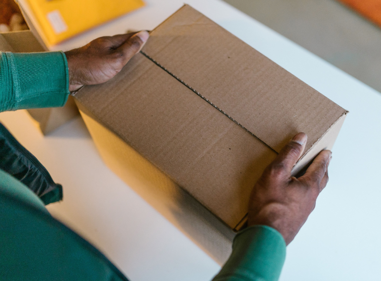 Persona preparando su caja para su respectivo envió.