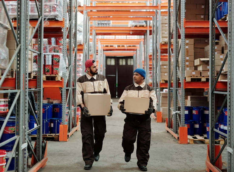 Trabajadores en almacén de fulfillment transportando paquetes 
