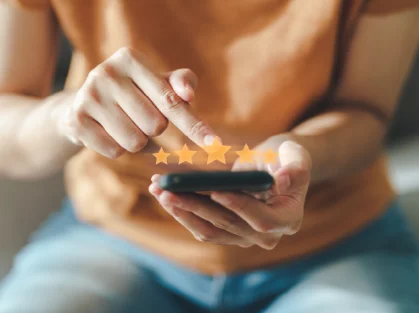 Persona calificando un servicio con cinco estrellas en un teléfono móvil.